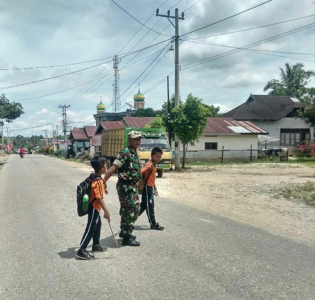 Serda Indra Jalin Bantu Anak SDN 01 Kelurahan Koto Peraku Menyebrang Jalan