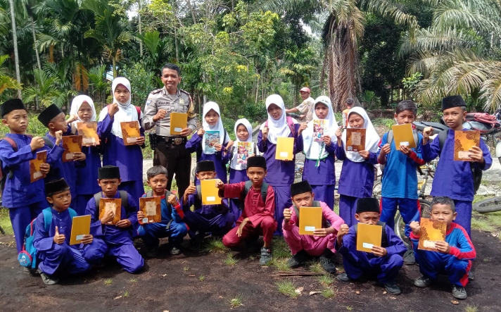 HUT RI ke-77, Bhabinkamtibmas Desa Sendaur Bagikan Buku Tulis Pada Anak-anak