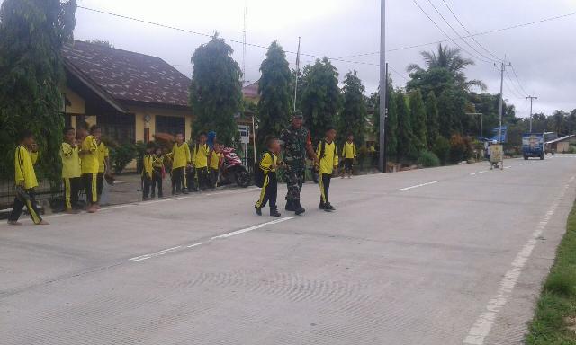 Anggota TNI Koramil 06 Cerenti Bantu Anak SD Menyeberang Jalan
