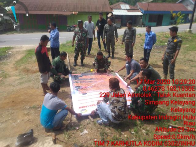 Masyarakat Bersama Danpos Koramil 04/PP Memasang Spanduk Himbauan Karhutla di Kelayang