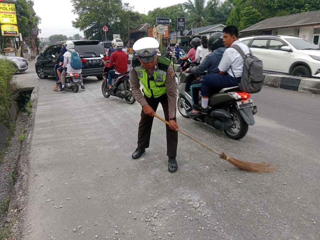 Bahayakan Pengguna Jalan Polisi Bersihkan Ceceran Pasir dan Kerikil di Jalan